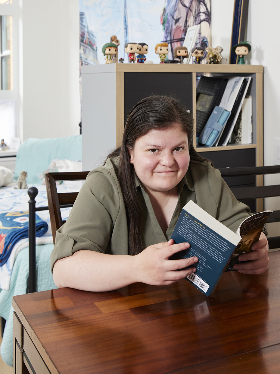 Smiling woman sitting at table and reading a book.