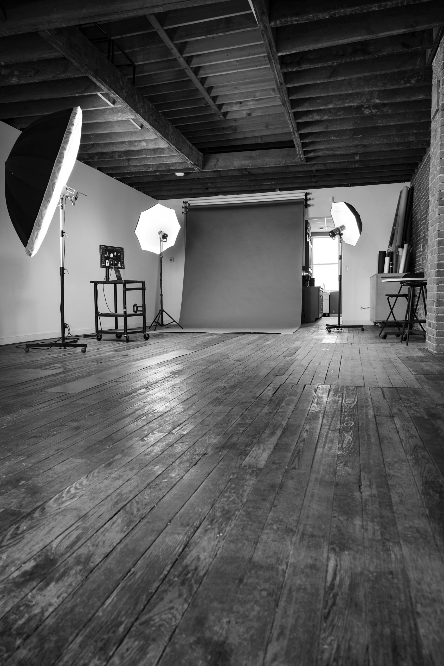 Black and white image of photo studio setup with backdrop and professional lighting
