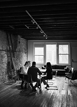 Group of colleagues conversing at table in studio