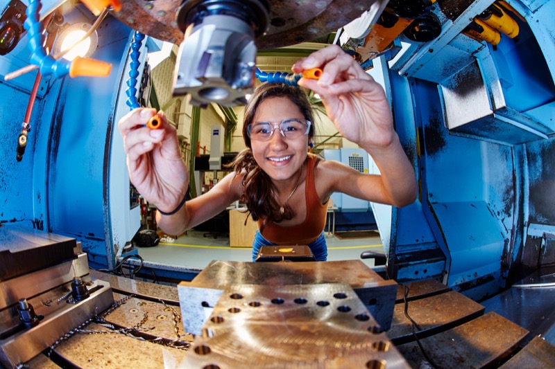 Smiling woman tinkering with machine
