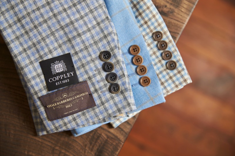 Stack of suit jacket sleeves with a 'Coppley' brand label