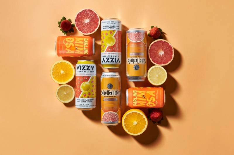 orange background with orange drink cans and orange fruits